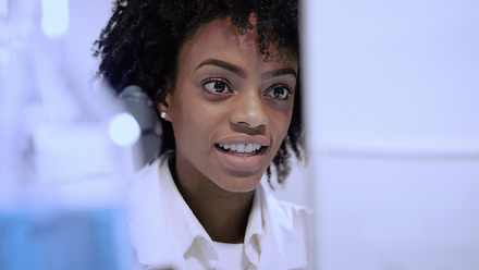 Woman researcher looking at a computer in a lab.