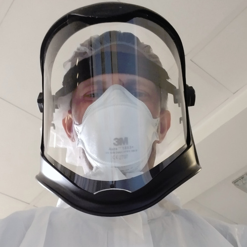Dr Skittrall wearing PPE whilst assessing patients for infectious diseases in his clinical practice