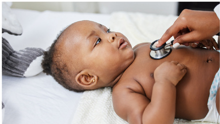 Baby laying on back being examined with stethoscope