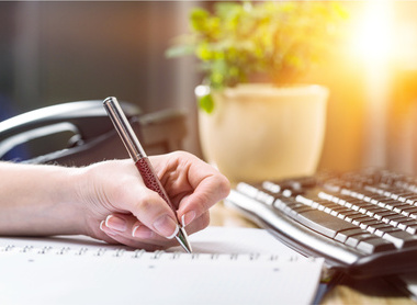 Female hand writting report at office workplace.jpg