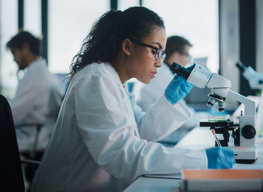 Scientist looking down microscope.jpg