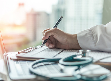 Doctor taking notes at laptop.jpg